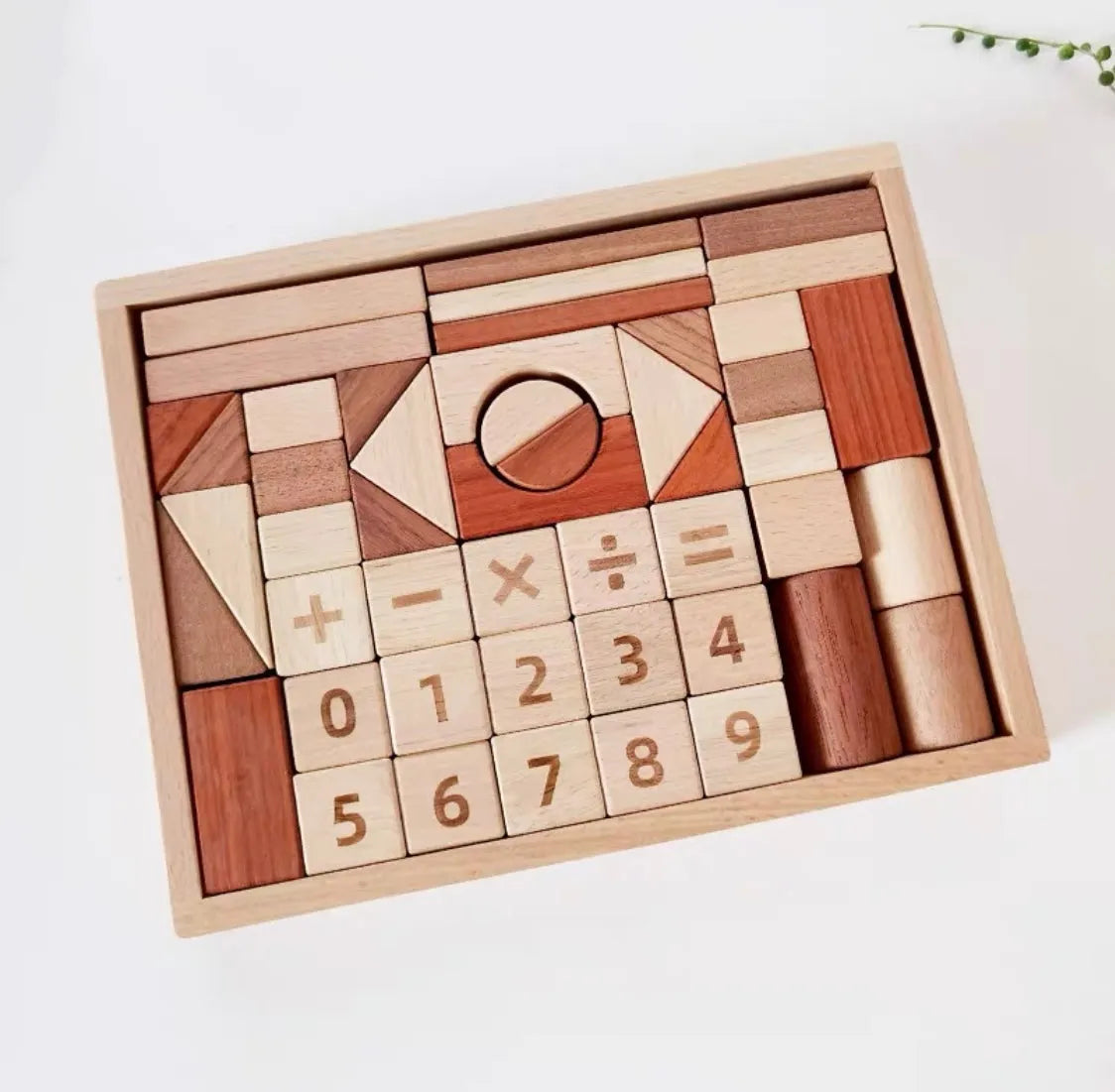 Wooden block set with numbers and mathematical symbols in a box on a white background