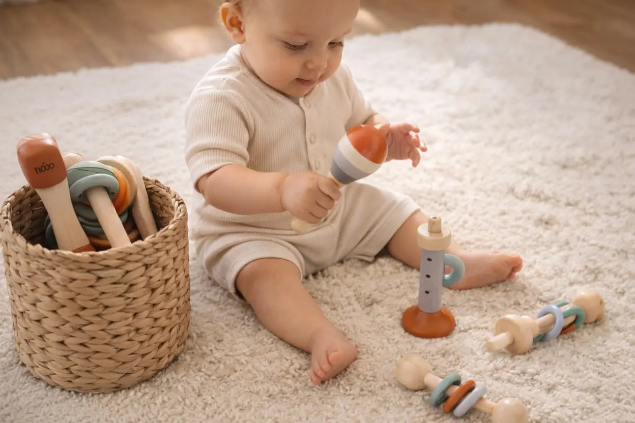 Toddler playing wooden xylophone and drum from instrument set