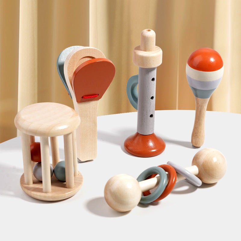 Set of colorful wooden toys on a white surface with a beige curtain background