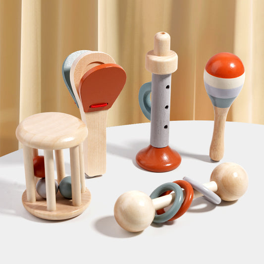 Set of colorful wooden toys on a white surface with a beige curtain background