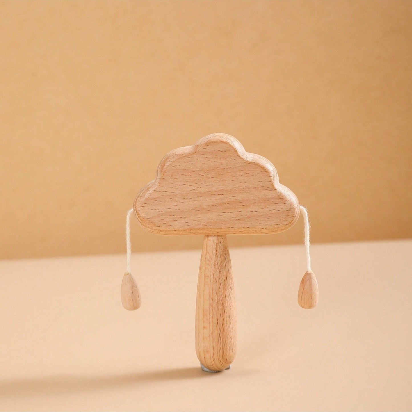 Wooden cloud-shaped rattle on a beige background