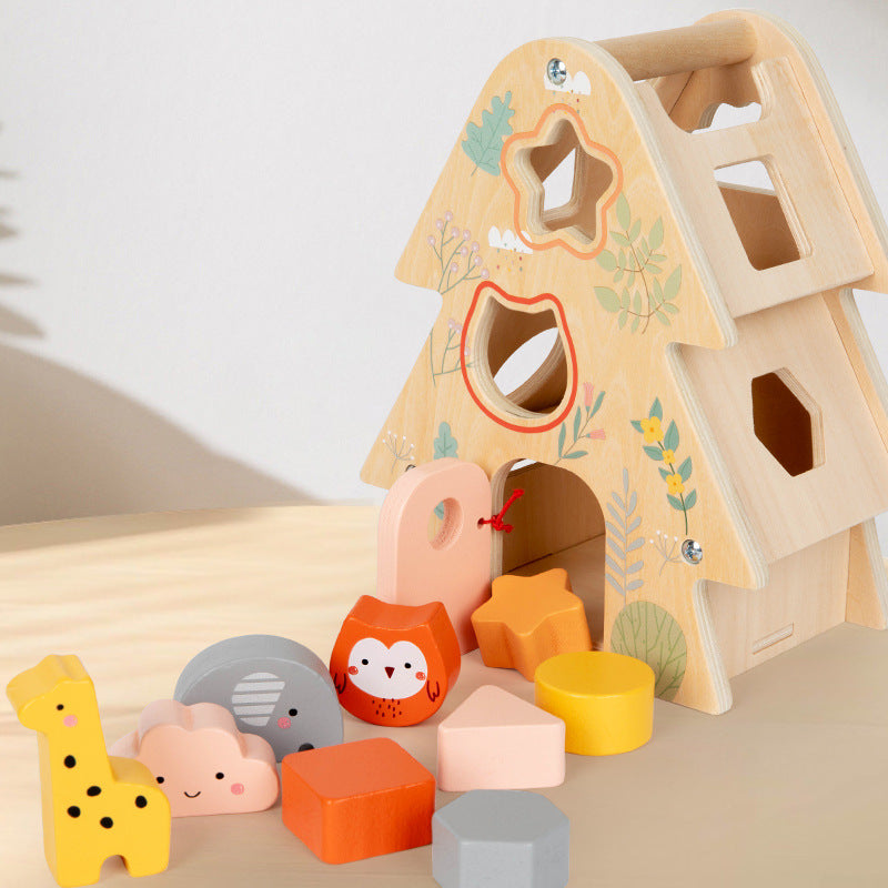 Wooden shape sorter toy with animal faces and colorful blocks on a light surface.