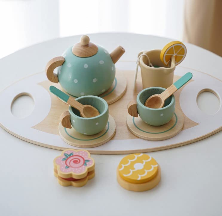 Children's toy tea set with teapot, cups, and cookies on a white surface.