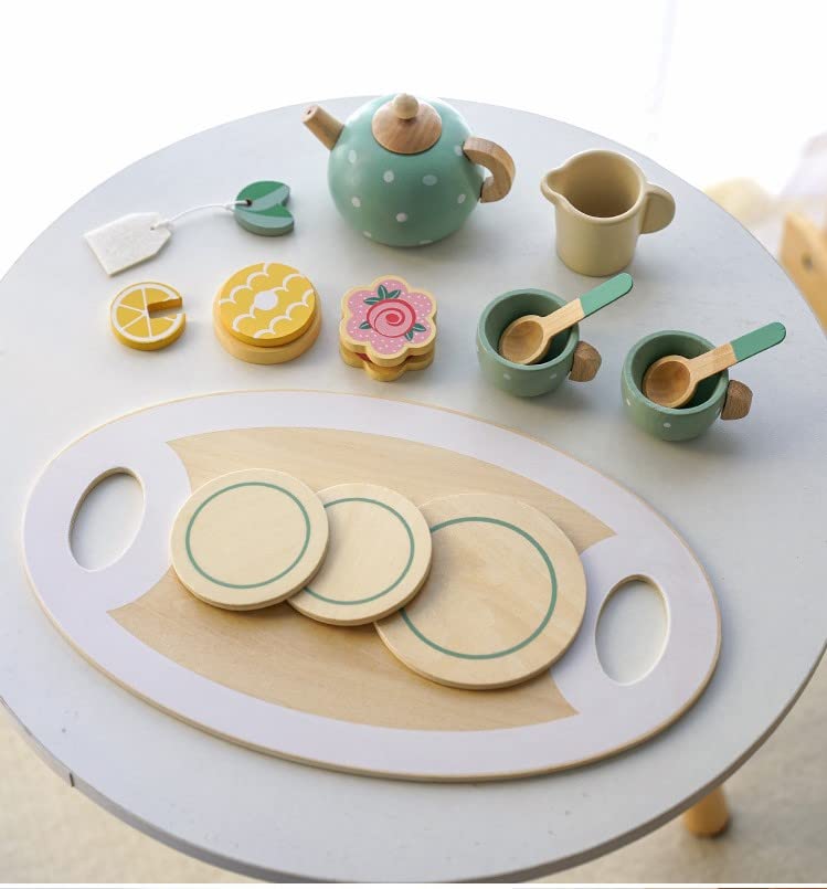 Children's tea set with wooden teapot, cups, and plates on a round table.