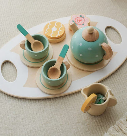 Children's toy tea set with cups, saucers, teapot, and cookies on a wooden tray.