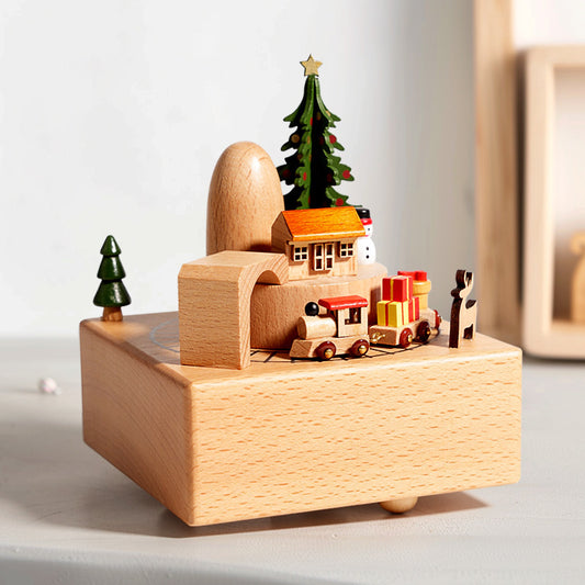 Wooden Christmas scene with a house, trees, and train on a white surface