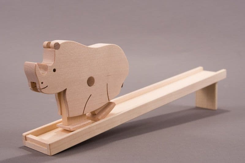 Wooden walking toy bear with a slide on a gray background