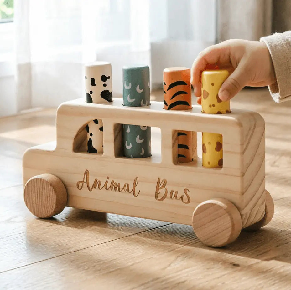 toddler pressing wooden pop-up animal bus toy with forest animal figures