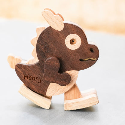A personalized wooden rocking dragon toy named 'Henry', featuring a dark brown wood body with light natural wood accents, shown on a neutral gray surface.