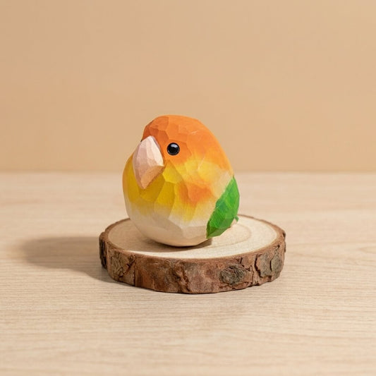 Handcrafted geometric wooden bird figurine with orange yellow gradient and green wings, natural wood toy lovebird on rustic wood slice display