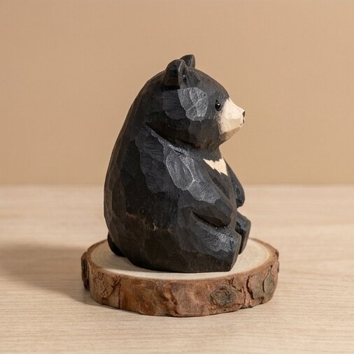 Wooden bear figurine on a wooden base against a beige background