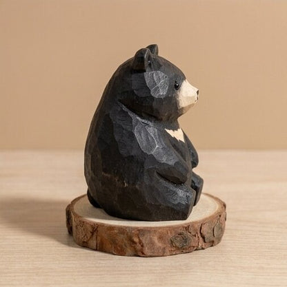 Wooden bear figurine on a wooden base against a beige background
