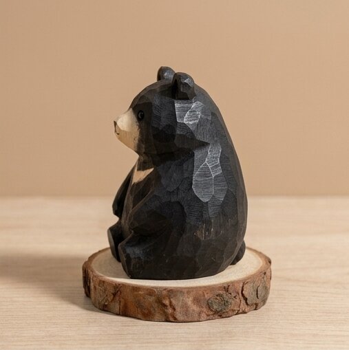 Wooden bear figurine on a natural wood base against a beige background