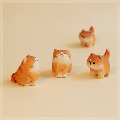Four small figurines of cats and dogs on a beige background
