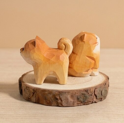 Wooden dog and cat figurine on a wooden base with a warm glow