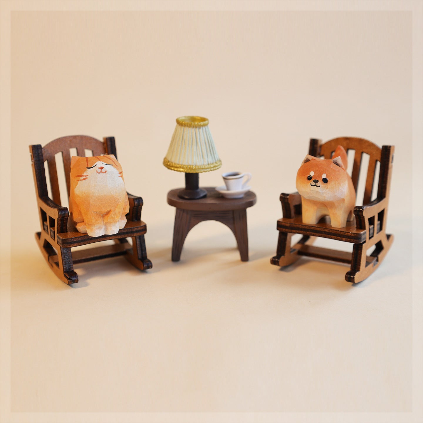 Two plush toys resembling dogs on wooden chairs with a small table and lamp in the center.