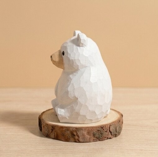 White bear figurine on a wooden base against a beige background
