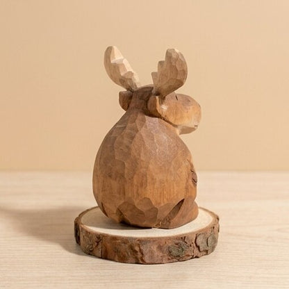 Wooden moose figurine on a beige background