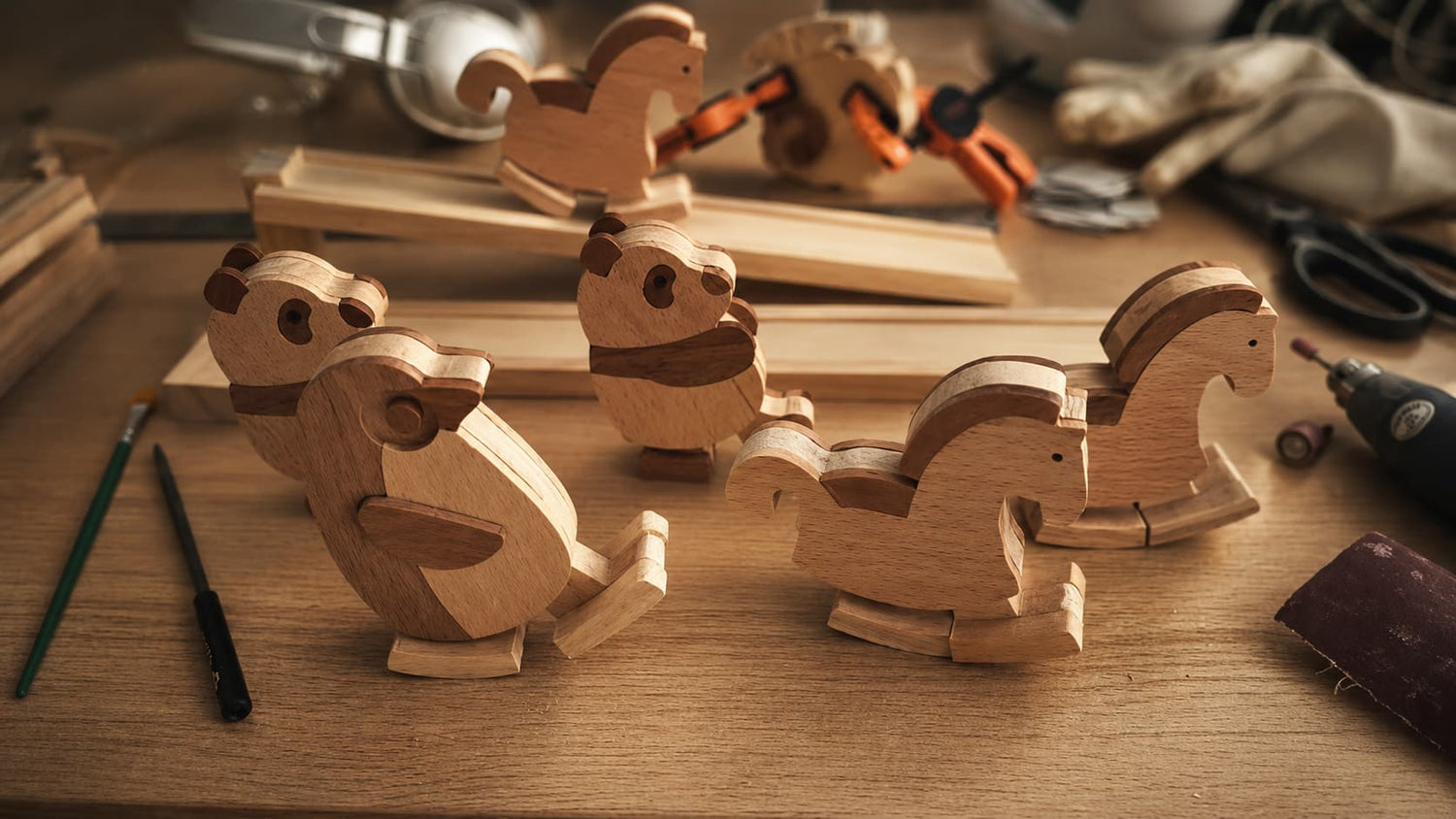Handmade wooden ramp walker toys displayed on a warm woodworking workshop table