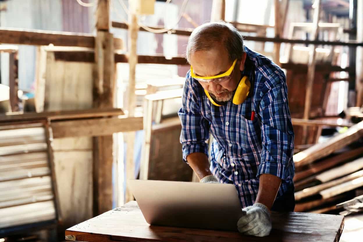 Wooden Toy Story B2B custom manufacturer reviewing client project specs in workshop, Chinese wooden toy OEM supplier