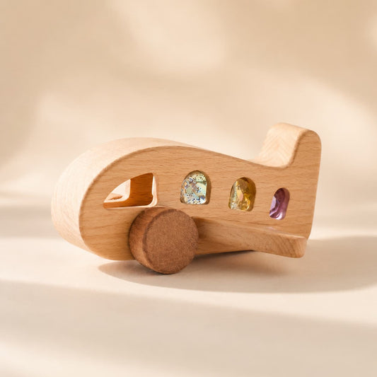 Montessori wooden airplane toy made of beechwood and walnut, featuring colorful translucent gem windows to encourage sensory exploration and imaginative pretend play for toddlers.