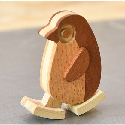 Wooden penguin figurine on a plain background