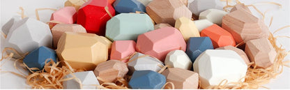 Colorful handcrafted wooden stacking stones on straw, Montessori toy for kids