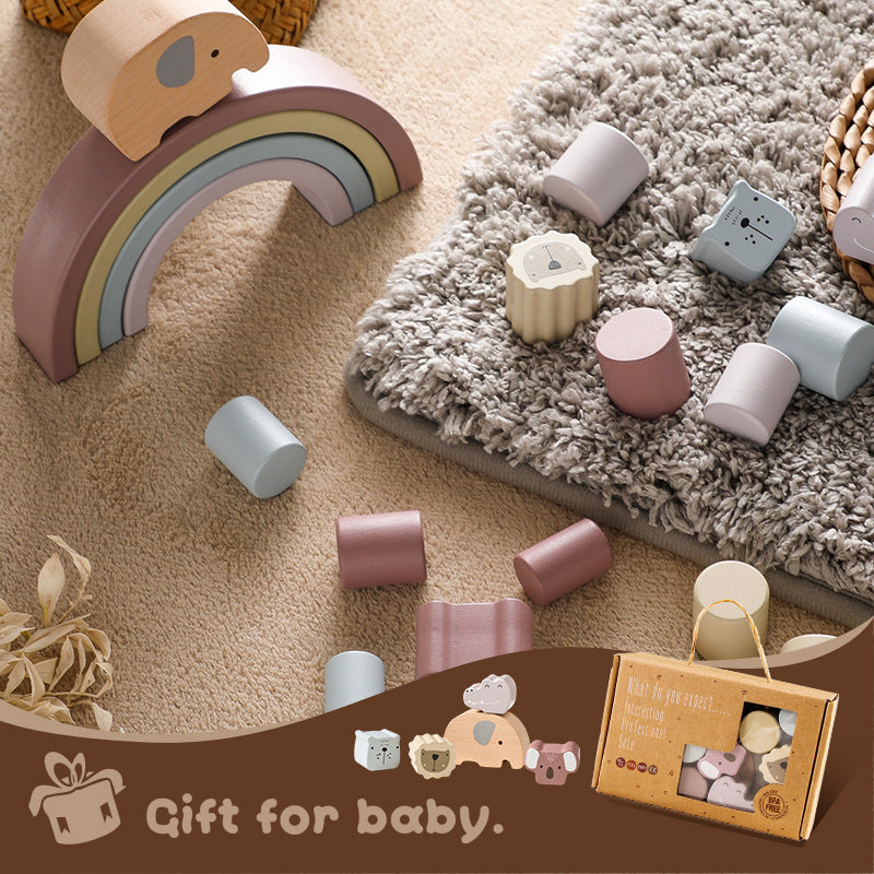 Wooden toys including a rainbow and cylindrical blocks on a carpet with a gift box labeled 'Gift for baby.'