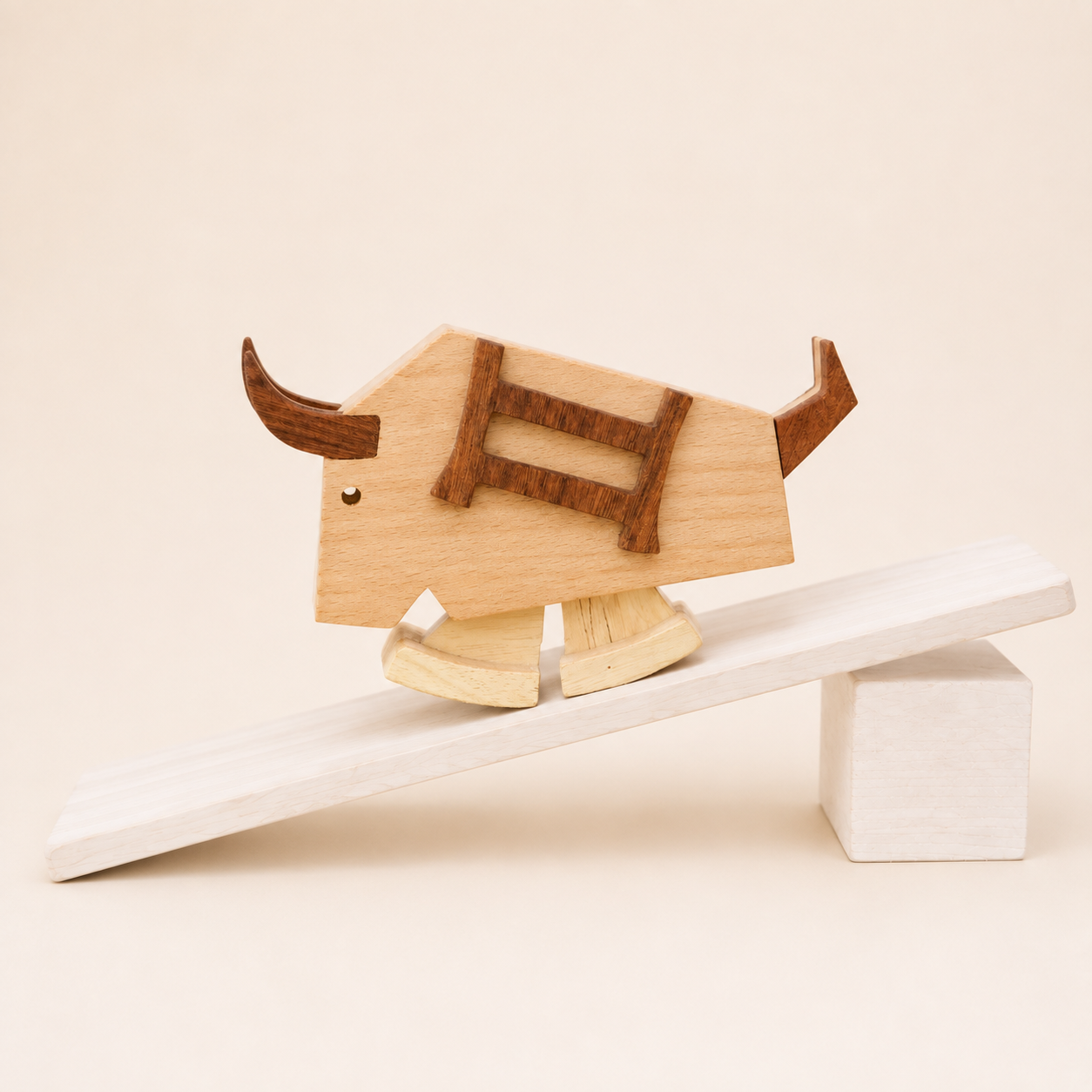 Handmade wooden bull ramp walker toy with dark wood horns and ladder detail, walking down a gently sloped wooden ramp.