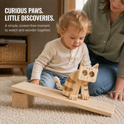Toddler watching a wooden cat ramp walker move down a wooden ramp with an adult nearby.