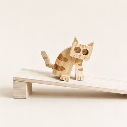 Wooden cat ramp walker toy stepping down a white wooden ramp.