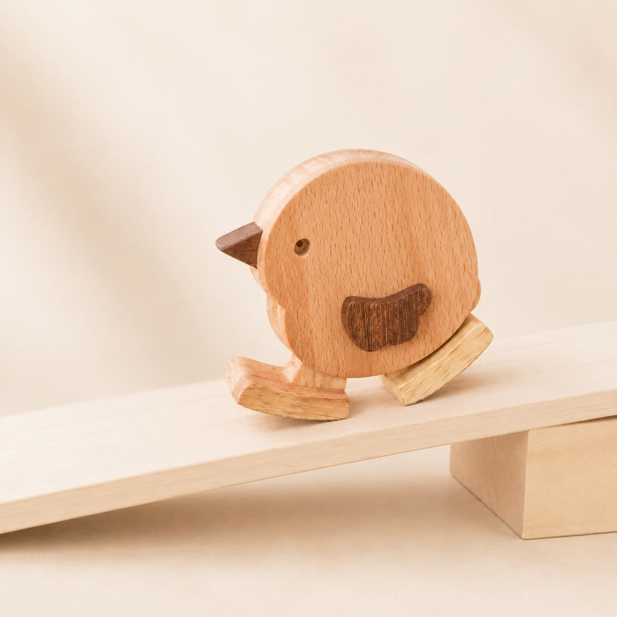 Wooden chicken ramp walker toy taking small steps down a gentle wooden ramp
