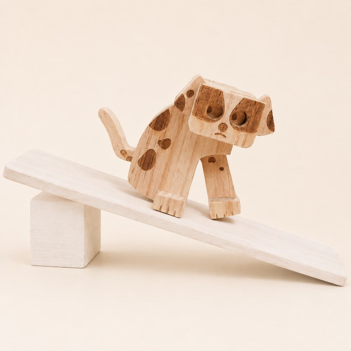 Handmade wooden dog ramp walker toy walking down a gently sloped wooden ramp.