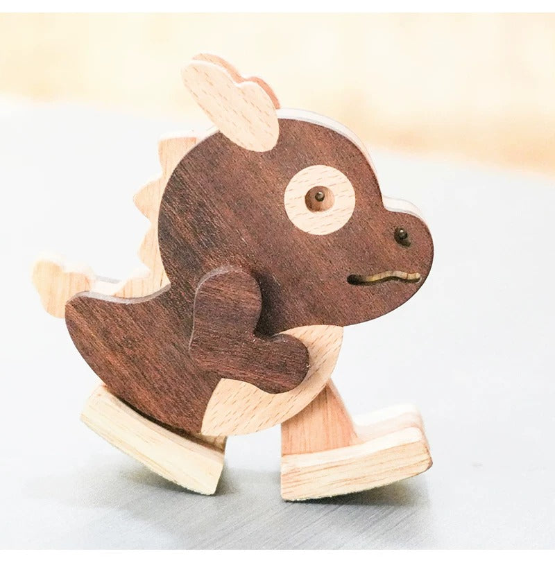 A wooden rocking dinosaur toy with a dark brown inlay and light natural wood accents, shown on a neutral light gray surface.