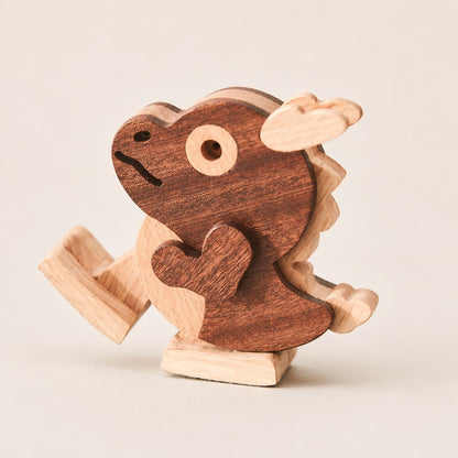 A small wooden dragon toy with a dark brown body and light natural wood accents, photographed on a plain light beige background.