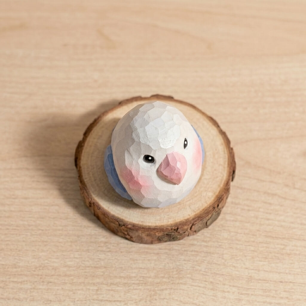 Top-down view white and blue wooden lovebird toy showing faceted head design, handcrafted geometric bird figurine non-toxic paint eco-friendly wooden toy for nursery decor