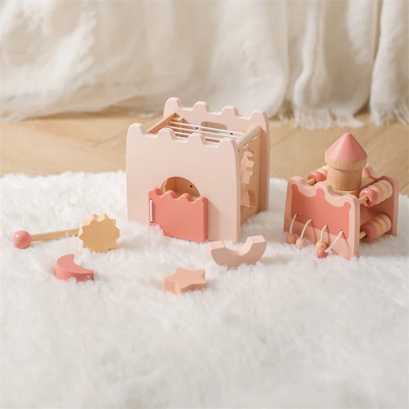 Set of pink wooden toys on a soft white surface with a blurred background