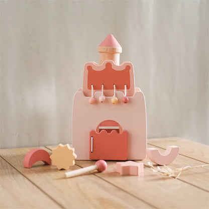 Wooden toy with pink and orange colors on a wooden surface