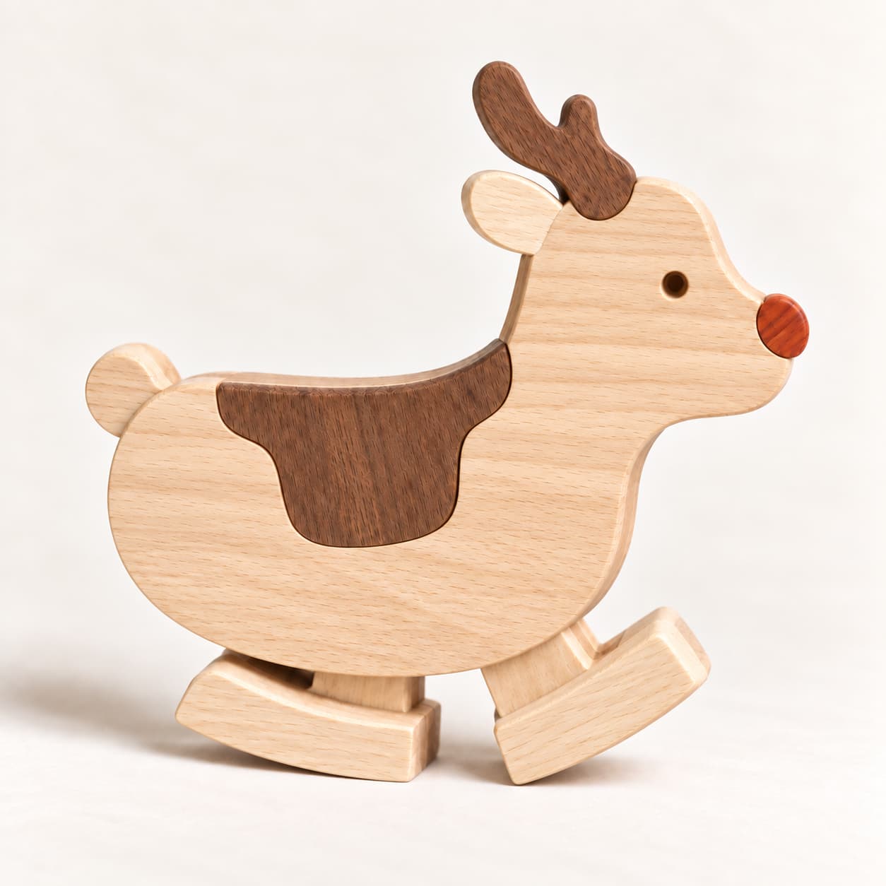 Wooden reindeer ramp walker toy with a red nose, brown antlers and curved wooden feet on a cream background.