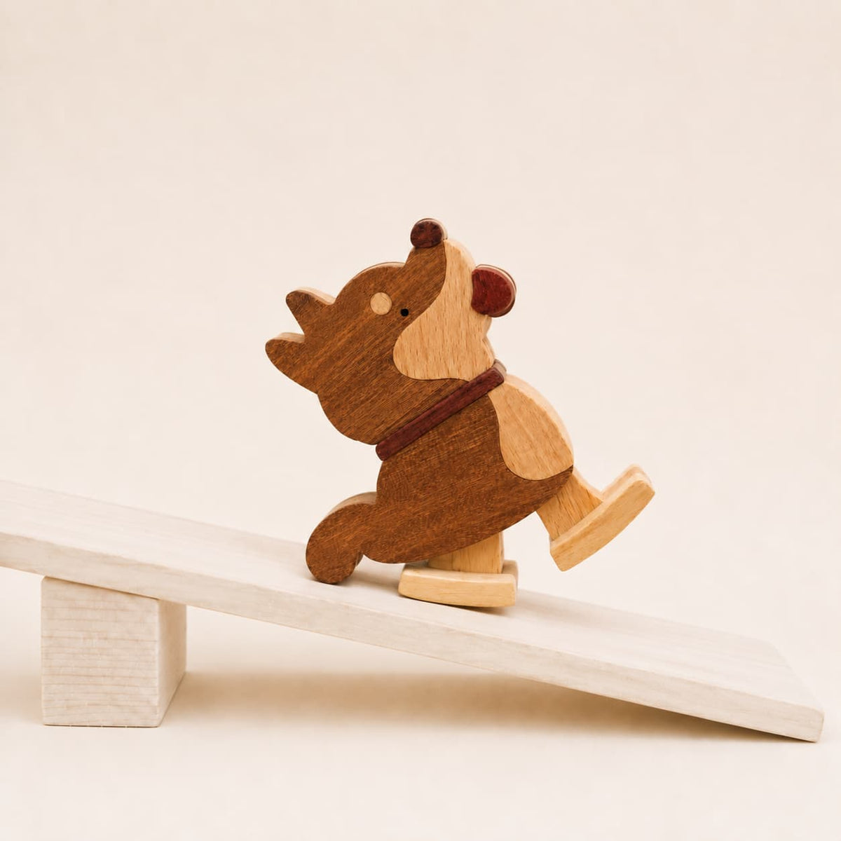 Handmade wooden Shiba Inu ramp walker toy walking down a gently sloped wooden ramp.