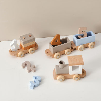 Set of wooden toy trains with number blocks on a light surface
