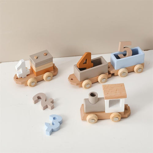 Set of wooden toy trains with number blocks on a light surface